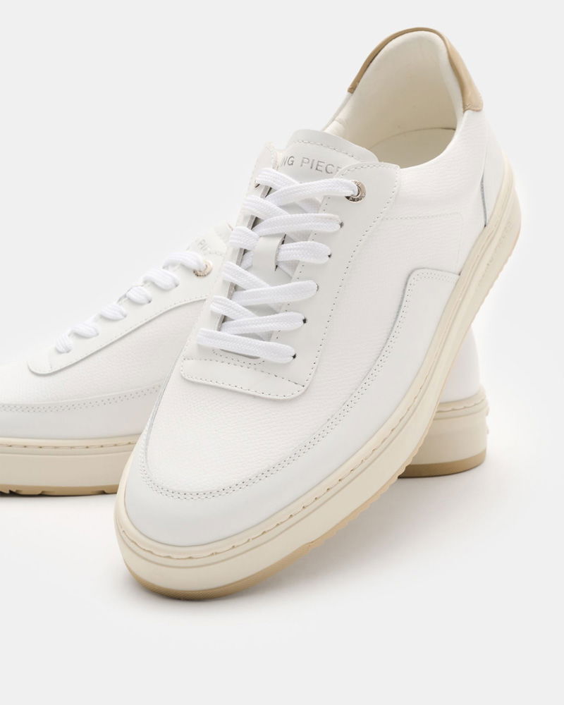 Weiße Sneaker aus Leder mit beiger Sohle und Fersenkappe, weißen Schnürsenkeln und feiner Nahtdetails.