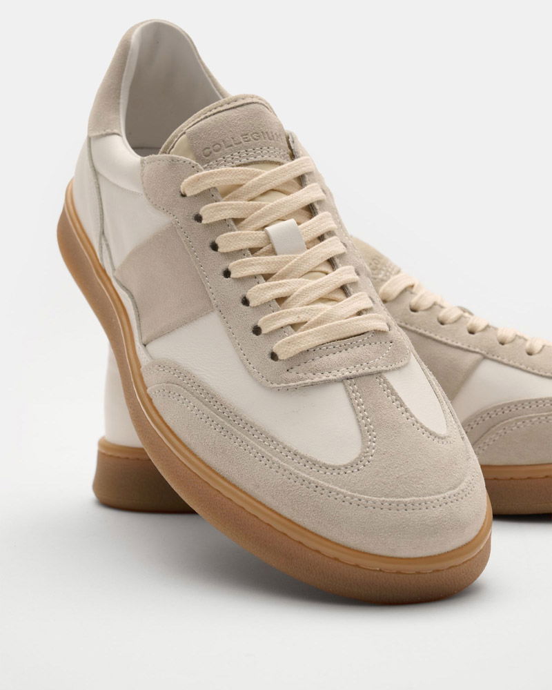 Pair of beige and white suede sneakers with cream laces and gum rubber soles on a white background.
