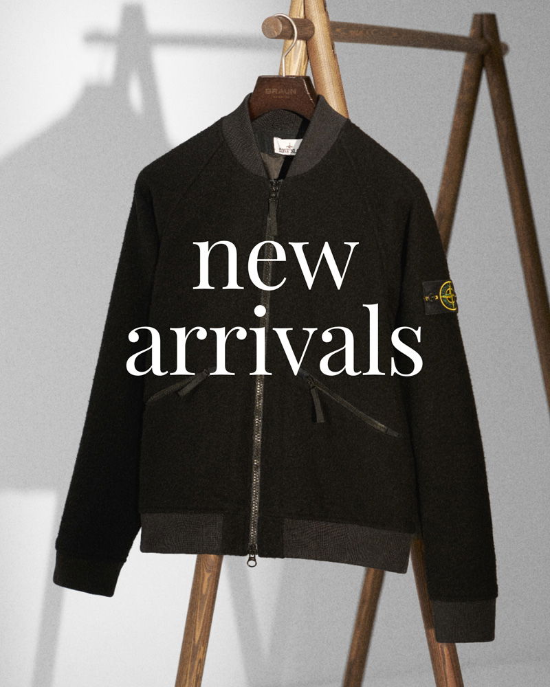 Black zip-up bomber jacket with ribbed cuffs and collar hanging on wooden stand, 'new arrivals' text overlayed.