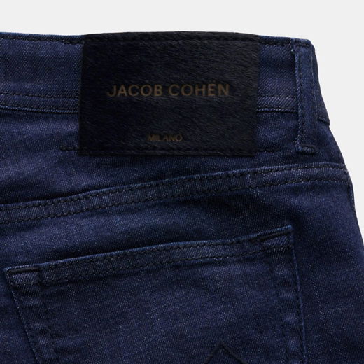Dunkelblaue Jeans mit schwarzem Lederetikett 'JACOB COHEN MILANO' über der Gesäßtasche, Nahaufnahme des hinteren Bunds. Dunkelblaue Jeans mit schwarzem Lederetikett 'JACOB COHEN MILANO' über der Gesäßtasche, Nahaufnahme des hinteren Bunds.