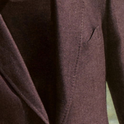 Brauner Wollmantel mit Reverskragen und Nahtdetails, Nahaufnahme des Oberteils und Ärmels.