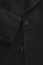 Close-up front view of the Cesare Attolini Cashmere Coat dark grey patterned, showcasing soft cashmere wool, double-breasted buttons, peak lapel, and classic breast pocket. Classic by CESARE ATTOLINI: This noble coat is made of cashmere with a virgin wool