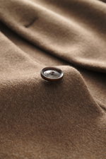 Close-up front angle of Montecore Cashmere Coat taupe showing soft pure cashmere fabric and branded four-button detail.