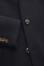 Close-up front view of the Mandelli Jacke navy showing fine navy pure new wool fabric, smooth texture, buttons on sleeve cuffs and front, highlighting timeless elegance, slim fit, two-way zipper, wind flap with buttons, stand-up collar, half-lined with tw