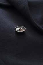 Close-up shot from above of a single dark brown button sewn on soft navy cashmere fabric of the Mandelli Cashmere Jersey-Jacke navy. <p>Purer Luxus für die Übergangszeit: Diese formschöne, ungefütterte Jersey-Jacke aus Cashmere von MANDELLI ist easy zu st