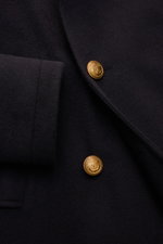 Close-up front angle of Sealup Pea coat 'Maestrale' navy showing fine wool-cashmere blend fabric, gold-coloured branded buttons, wide lapel collar, and slanted hip pocket, inspired by nautical clothing. Features lightweight padding, double-breasted three-