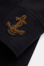 Close-up side view of navy wool-cashmere blend Sealup Pea coat 'Maestrale' sleeve displaying gold anchor embroidery, highlighting fine fabric texture.