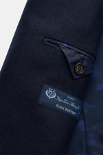 Close-up from above of the navy Sealup Pea coat 'Amalfi Peacoat' showing soft pure wool fabric, button, label, and inner pocket lining.