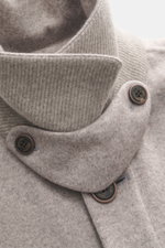 Close-up image from an angled top-front perspective of the Colombo Kid Cashmere fleece coat grey/taupe melange, highlighting its pure cashmere fabric with a very soft touch, five-button placket with Colombo-branded buttons, turn-down collar with tab, and 