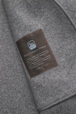 Close-up angled view of the Colombo Kid Cashmere fleece coat grey/taupe melange showing soft pure cashmere fabric and stitched label.

This coat made of pure kid cashmere fleece from the traditional house COLOMBO embodies luxury in its purest form. Its re