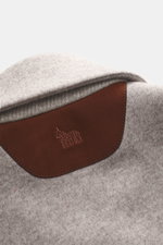 Close-up from above of the Colombo Kid Cashmere fleece coat grey/taupe melange showing soft pure cashmere fabric and brown velour leather detail with embroidered logo.