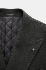Close-up front view of Tagliatore Wool Coat Dark Grey Melange showing peaked lapel with pin, soft virgin wool fabric, and quilted half-lined interior.

Description: <p>TAGLIATORE's signature understated elegance is expressed through this impeccably tailor