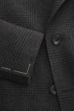 Close-up front view of Tagliatore Wool coat dark grey/anthracite checked, showcasing pure new wool fabric, soft feel, classic Glen check pattern, double-breasted style with black buttons, peaked lapel with pin, and visible stitching details.

Description: