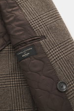 Close-up top-down view of Tagliatore Wool coat taupe/dark brown checked showing Glen check wool fabric, quilted brown lining with brand label, and black button.

Description: Classic elegance from TAGLIATORE: Made from pure wool in a timeless Glen check p