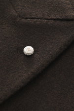 Luigi Bianchi Wool coat dark brown melange close-up from above showing soft virgin wool fabric and white pin on lapel, double-breasted.