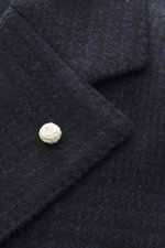 Close-up front view of Luigi Bianchi Wollmantel dunkelgrau meliert showing textured dark grey wool fabric and white button, Italian craftsmanship in exclusive men's fashion with pure new wool, soft touch, slim fit, double-breasted three-button style, peak