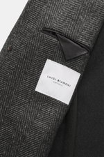 Close-up view of the inner lining and label of the Luigi Bianchi Wollmantel dunkelblau/navy kariert in herringbone pattern, showing smooth black pocket lining and fabric texture.

Description: <p>Italienische Handwerkskunst vereint in exklusiver Herrenm