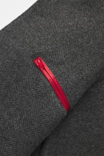 Nahaufnahme des Fischgratmusters und roten Karabinerverschlusses am Ärmel des Fay Mantel 'Duty Coat' dunkelgrau meliert aus Wolle-Microfaser-Mix, halb gefüttert.