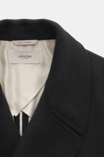 Agnona Cashmere Coat Black shown from a close-up front angle, featuring pure cashmere, heavy jersey, soft touch, regular fit, wide lapel collar, double-breasted three-button closure, slanted welt pockets, center back vent, and unconstructed design; for el