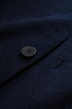 Close-up front detail of the Lunaria Cashmere Cashmere short coat navy showing a four-button style, notched collar, and flap pocket from above.