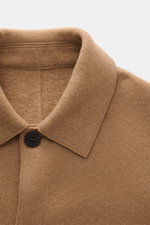 Close-up front view of Lunaria Cashmere Cashmere short coat light brown showing notched collar and black four-button detail, pure cashmere, very soft feel, regular fit, front pockets with flap, center back vent, unlined, one inner pocket, timeless eleganc