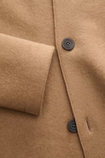 Close-up front view of the Lunaria Cashmere Cashmere short coat light brown showing soft pure cashmere fabric, four-button style, and sleeve detail. Timeless elegance, masterfully staged: The exclusive short coat from LUNARIA CASHMERE combines a clear, no