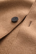 Close-up front view of the Lunaria Cashmere Cashmere short coat light brown showing the soft texture, black button, and stitching details.

Description: 
<p>Timeless elegance, masterfully staged: The exclusive short coat from LUNARIA CASHMERE combines a c
