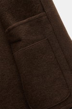 Close-up view of the front pocket and soft texture of the Lunaria Cashmere Cashmere short coat dark brown, highlighting pure cashmere fabric and fine stitching. Timeless elegance, masterfully staged: The exclusive short coat by LUNARIA CASHMERE combines a