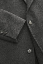 Close-up front view of Ami Paris Wool coat dark grey melange, showcasing pure new wool, textured quality, oversized fit, two-button placket, notched lapel, classic breast pocket, slanted welt pockets, sleeve cuffs with buttons, center back vent, smooth li
