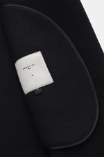 Close-up view of the Percival Coat 'Minnesota' navy label and fabric, showcasing pure wool, soft touch, Regular Fit, five-button placket, turn-down collar, side seam pockets, and unconstructed design.