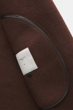 Close-up detail of the Percival Coat 'Minnesota' brown/white melange showing soft wool blend fabric, unconstructed design, and inner label, photographed from an angled side view. Mix of wool, microfiber, and cotton, twill with inserted slubs, regular fit,