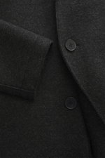Close-up front view of Harris Wharf London Wool coat dark grey melange showing felted virgin wool texture and buttons.

Description: Timeless, pure, and well thought out: This unlined coat with a straight silhouette from HARRIS WHARF LONDON, made from hea