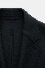 Close-up front view of Harris Wharf London Wool coat navy collar and upper chest, showing pure felted virgin wool texture and notch collar. Timeless, pure, and well thought out: This unlined coat with a straight silhouette from HARRIS WHARF LONDON, made f