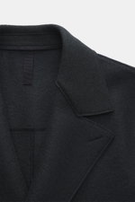 Close-up top-down view of Harris Wharf London Wollmantel navy showing heavy felted virgin wool fabric, broad notch lapel, and unlined interior with raw-edge finish.

<p>Zeitlos, pur und durchdacht: Dieser ungefütterte Mantel von HARRIS WHARF LONDON aus sc