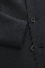 Close-up front view of Harris Wharf London Wollmantel navy made of heavy, felted virgin wool with button detail, raw-edge finish, and visible texture. Zeitlos, pur und durchdacht: Dieser ungefütterte Mantel von HARRIS WHARF LONDON aus schwerer, gefilzter 