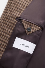 Close-up inside view of Lardini Coat brown/beige pattern showing smooth lining fabric, buttoned slanted welt pocket, label, and houndstooth weave made of virgin wool and cashmere.