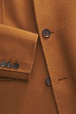Nahaufnahme des Windsor Mantel 'Cesarino' hellbraun aus reiner Wolle, weicher Griff, Slim Fit, Drei-Knopf-Leiste, Reverskragen, Brusttasche, drei Fronttaschen mit Patte, Kissing Buttons, Rückenmittelschlitz, ungefüttert, eine Innentasche, fotografiert aus