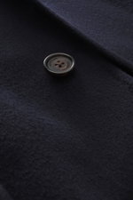 Nahaufnahme des navy-farbenen Windsor Mantel 'Cesarino' mit Fokus auf Knopf und reine Wolle, weicher Griff, Slim Fit, Drei-Knopf-Leiste, Reverskragen, klassische Brusttasche, drei Fronttaschen mit Patte, Kissing Buttons, Rückenmittelschlitz, ungefüttert, 