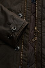 Nahaufnahme des Barbour Wachsparka 'Beaudale' khaki von vorne, gewachste Baumwolle, wattiert, mit Reißverschluss und Knöpfen.