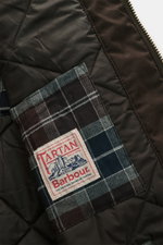 Nahaufnahme des gesteppten Innenfutters mit Barbour Tartan-Label im Barbour Wachsparka 'Beaudale' khaki aus gewachster Baumwolle.