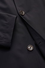 Close-up, angled top view of Moorer Kurzmantel 'Hektor' navy showcasing water-repellent microfiber, smooth texture, slim fit, four-button placket, and neat stitching. Urban design with standing collar and hidden hood.