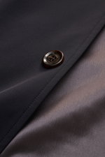 Close-up of the button and fabric edge of the Moorer Kurzmantel 'Hektor' navy, showing smooth microfiber and silky inner lining from a top-down perspective. Urban style meets functional features like water-repellent material, stand-up collar with hidden h