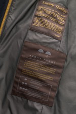 Nahaufnahme des Innenfutters der Moorer Jacke 'Borromeo' navy mit wasserabweisendem Finish und Luxury Quality Etiketten.