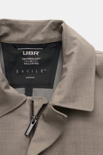 Close-up front view of UBR Rain coat 'Sky Fall Savile' taupe mottled, showing collar, zipper, and inner label with branding.

<p>The incredibly lightweight rain coat 'Sky Fall Savile' by UBR is made of smart merino wool and microfibre for effortless prote