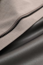 Close-up detail of the black zipper on taupe mottled fabric of UBR Rain coat 'Sky Fall Savile' from above, showing texture.

<p>The incredibly lightweight rain coat 'Sky Fall Savile' by UBR is made of smart merino wool and microfibre for effortless protec