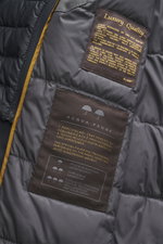 Nahaufnahme des Innenfutters vom Moorer Daunen-Kurzmantel 'Redon' navy, wasserabweisend, mit leichter Daunenfüllung und Qualitätslabeln.