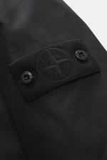 Close-up front view of the Stone Island Trenchcoat 'Ghost Piece' navy showing the tonal compass badge on upper arm, pure cotton fabric, Regular Fit, smooth button placket, turn-down collar with tab, front pockets with flap and press studs, buttoned sleeve