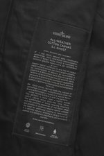 Close-up interior view of the Stone Island Trenchcoat 'Ghost Piece' navy showing the fabric label with detailed care and material information, pure cotton, Regular Fit, smooth button placket, turn-down collar with tab, front pockets with flap and press st