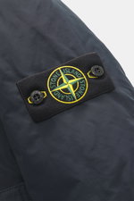 Stone Island Daunen-Kurzmantel 'Micro Reps' navy, Detailansicht des typischen Kompass-Badges aus hochwertiger Microfaser mit glattem Griff, wind- und wasserabweisend, Slim Fit mit wattierter Kapuze, zwei-Wege-Reißverschluss, Windblende mit Knöpfen, paspel