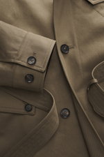 Close-up front view of Belstaff Trenchcoat 'Supersenia' gray-brown showing cotton twill fabric, buttoned cuffs, slanted chest pocket, and four-button style.
